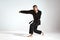 Fighting guy in black kimono fighter demonstrating karate technique on studio background with copy space