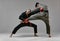 Fighting guys during mixed fight workout on gray studio background. Athletic males in kimono and boxing gloves training