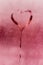 Figure heart on the glass. The texture of misted glass. Drops on the glass. Bright pink color picture. Valentine`s Day