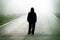 Figure of a man walking on a foggy road