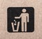 Figure of person throwing garbage into a trash can.
