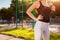 Figure of young woman athlete standing on sportsground in summer. Sportive slim body.