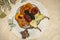 Figured napkin with a crystal rosette filled with dried fruits,and small eclairs on plywood