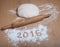 Figures 2016 on a flour on a light wooden table. Selective focus
