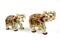 Figures of a pair of white elephants in marble with red and gold painting isolated on white background Traditional Indian souvenir