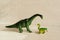 Figurine of a bracheosaurus and its cub. offspring care concept. plastic dinosaur figures of extinct ancient creatures and