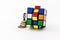 Figurine on coins climbing on rubik cube