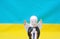 Figurine of an praying angel on Ukrainian national flag, blue and yellow