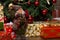 Figurine Santa Claus holding a gift standing near Christmas tree