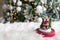 Figurine of santa claus on a white fur blanket, against the background of a burning garland of christmas tree