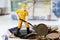 Figurine worker with shovel standing on pile of euro coins