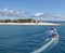 Fiji island best beach photo. Island with forest and cottage, natural panorama with boats with blue roofs.