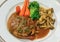 Filet Mignon steak with gravy sauce and carrot broccoli mushroom side-dish on dish in vintage color. It\'s a international French