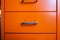Filing cabinet with closed drawer, Orange metal colour, Administration and storage concept, closeup & Macro shot