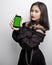 Filipina in a vampire costume holding a green screen phone on white background