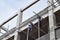 Filipino construction workers installing metal pipe scaffolds on high-rise building without protective suit.