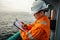 Filipino deck Officer on deck of offshore vessel or ship fills checklist. Paperwork at sea