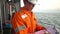 Filipino deck Officer on deck of offshore vessel or ship fills checklist. Paperwork at sea