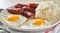 Filipino silog breakfast with garlic fried rice, longsilog, and two sunny side up eggs
