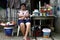 A Filipino woman sits and waits for customers at her makeshift store along a sidewalk