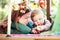 Filled with curiousity. Cute young mom lying alongside her infant son on the playroom floor.