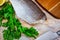 Fillet of raw codfish on a wooden surface with garlic and greens