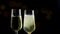 Filling flutes of champagne with golden bubbles against black and bokeh background, concept of golden luxury holiday happy