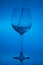 Filling the glass, pouring wineglass on blue background