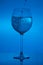 Filling the glass, pouring wineglass on blue background