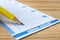 Filling out lottery ticket with pencil on wooden table, closeup