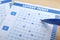 Filling out lottery tickets with pen on wooden table, closeup