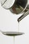Filling up a tablespoon of extra-virgin olive oil