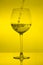 Filling wine glass on yellow background, pouring wineglass