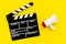 Film director, producer concept. Filming. Electronic megaphone and clapperbord on yellow background top view space for