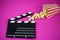 Film flap with popcorn on a pink background