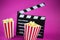 Film flap with popcorn on a pink background