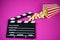 Film flap with popcorn on a pink background