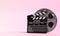 Film reel with clapperboard isolated on bright pink background in pastel colors