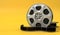 Film reel isolated on bright yellow background in pastel colors. Minimalist creative concept. Cinema, movie, entertainment concept