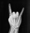 Film xray x-ray or radiograph of hand and fingers showing bones doing the sign language gesture for rock on devil horn seen at
