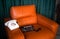 Filming some cinema movie..Vintage Brown leather armchair in loft design apartment..Old retro landline phone, sunglasses and