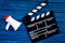 Filmmaker concept. Electronic megaphone and clapperbord on blue wooden background top view