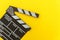 Filmmaker profession. Classic director empty film making clapperboard or movie slate isolated on yellow background. Video