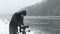 Filmmaker with tripod in street video taping in blizzard