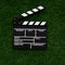 Filmmaking concept. Movie Clapperboard. Cinema begins with movie clappers. Movie clapper on a background of green lawn. Square