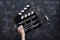Filmmaking concept. Movie Clapperboard. Cinema begins with movie clappers. Movie clapper board on a dark background and a hand