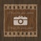 Filmstrip template with photo camera on wooden background