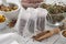 Filter tea bags filled with healthy medicinal herbs. Bowls and mortars of dry marjoram, heather and marigold flowers on table