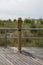 Filtered water bottle filler on a boardwalk neat a beach sand dune with high grass