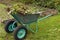 Final garden work of autumn. wheelbarrow in the garden full of dry leafs and branches. Autumn garden theme. Wheelbarrow into which